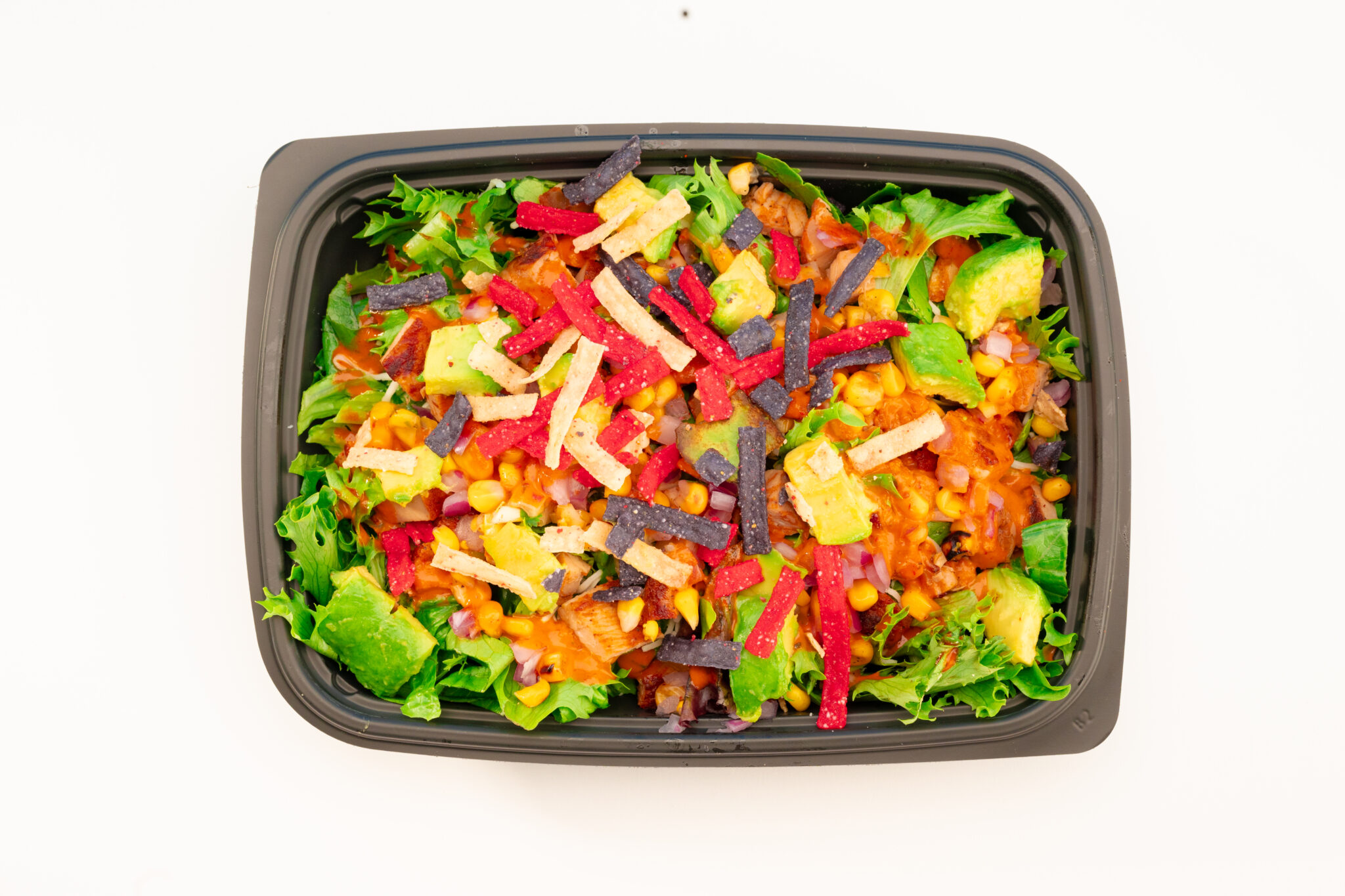 Overhead food photography of Freebirds Agave Adobo Salad with chicken, avocado, corn salsa, and tortilla strips