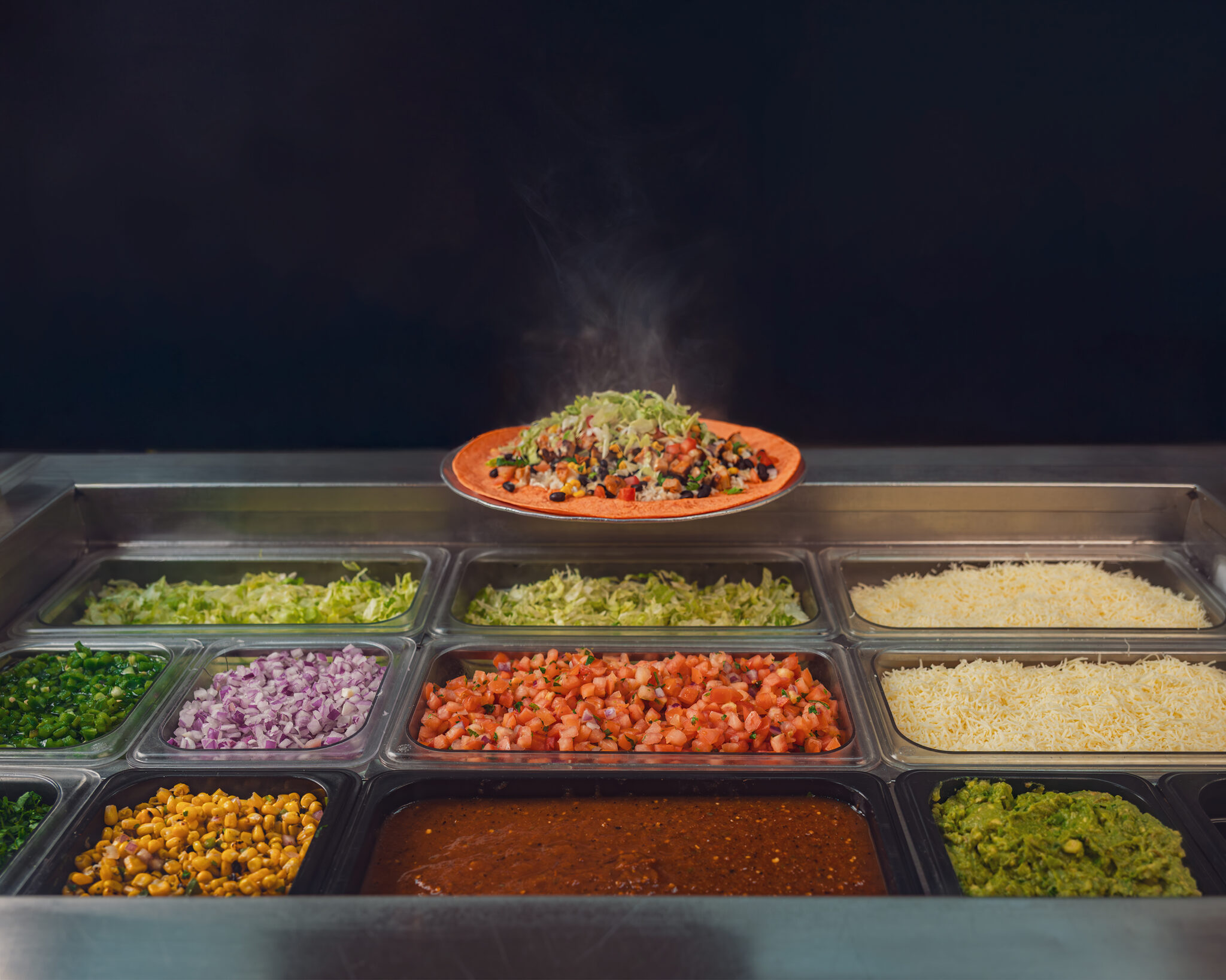 Freebirds ingredient line with burrito above fresh toppings for It’s Your World campaign