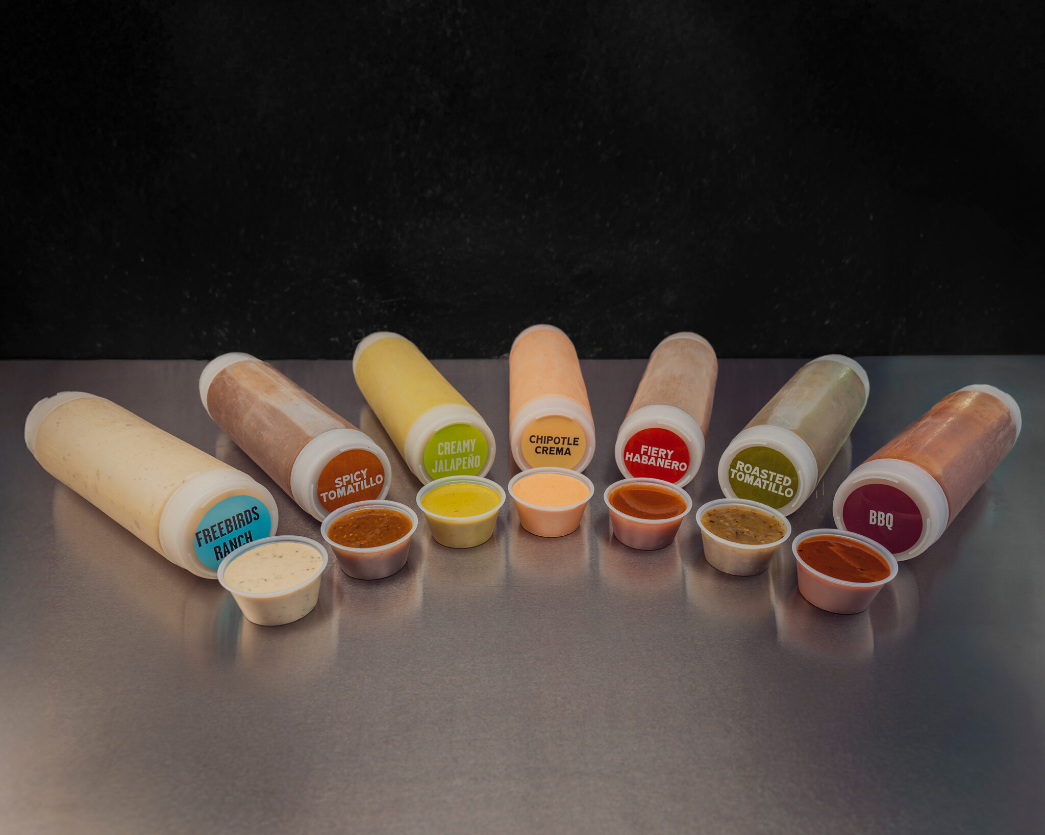 Freebirds sauce lineup featuring ranch, spicy tomatillo, creamy jalapeño, chipotle crema, fiery habanero, roasted tomatillo, and BBQ