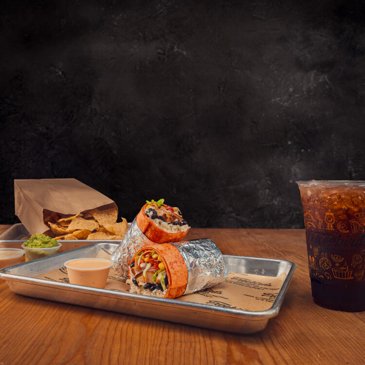 Freebirds It’s Your World campaign image with burrito, chips, sauces, and drink