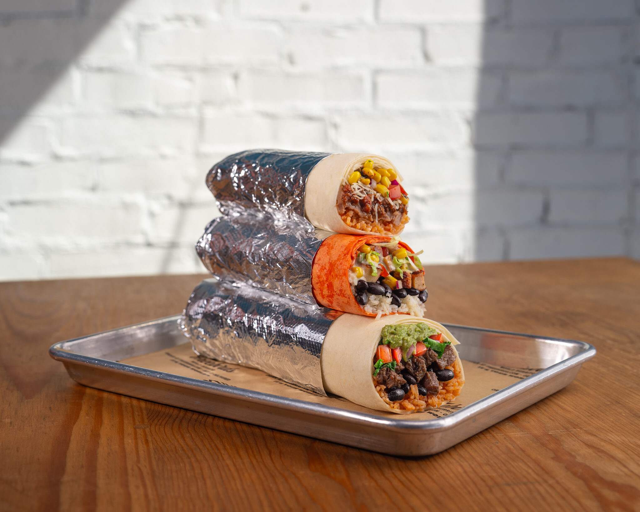 Stacked Freebirds burritos showing different tortilla colors and fresh fillings