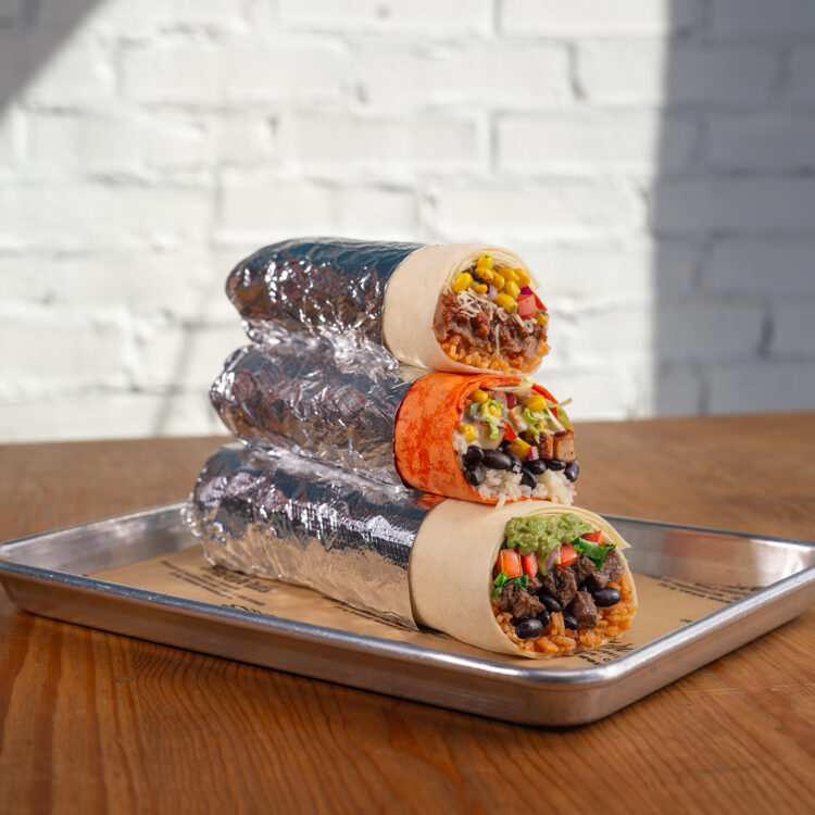 Stacked Freebirds burritos showing different tortilla colors and fresh fillings