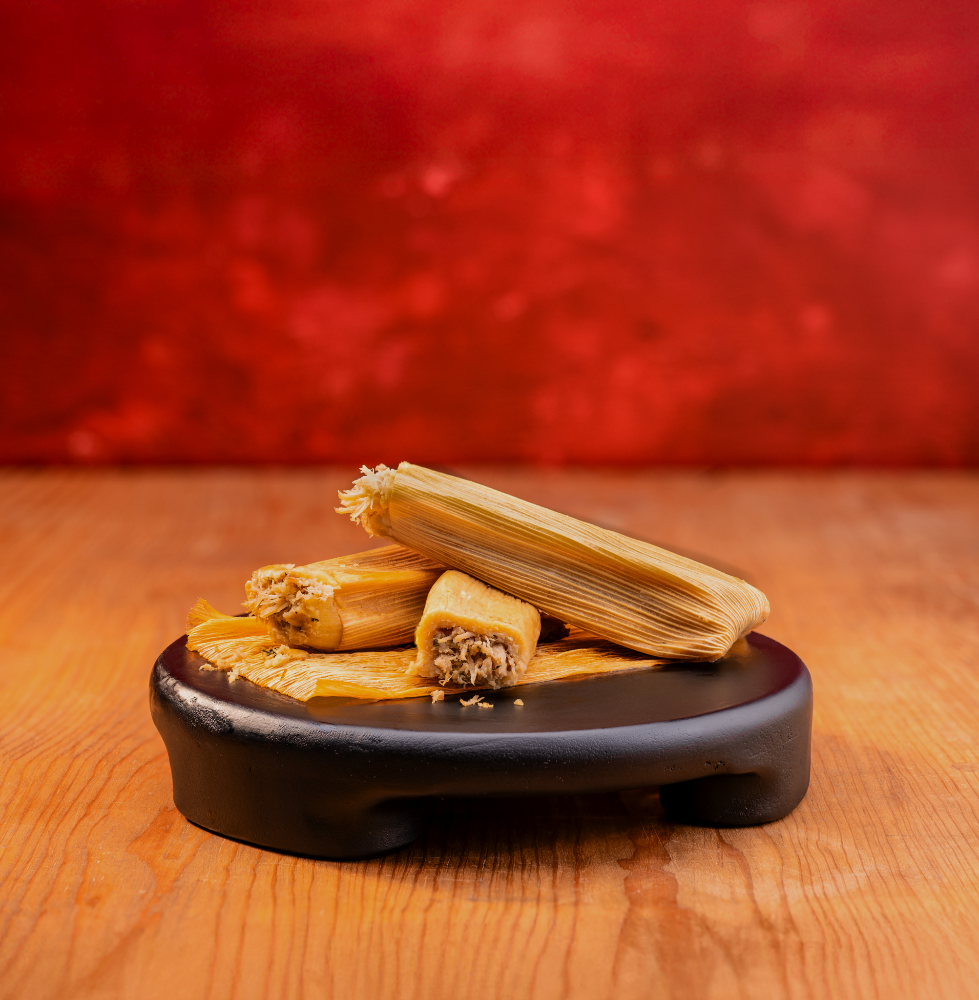 Taco Bueno chicken tamales stacked on black serving board
