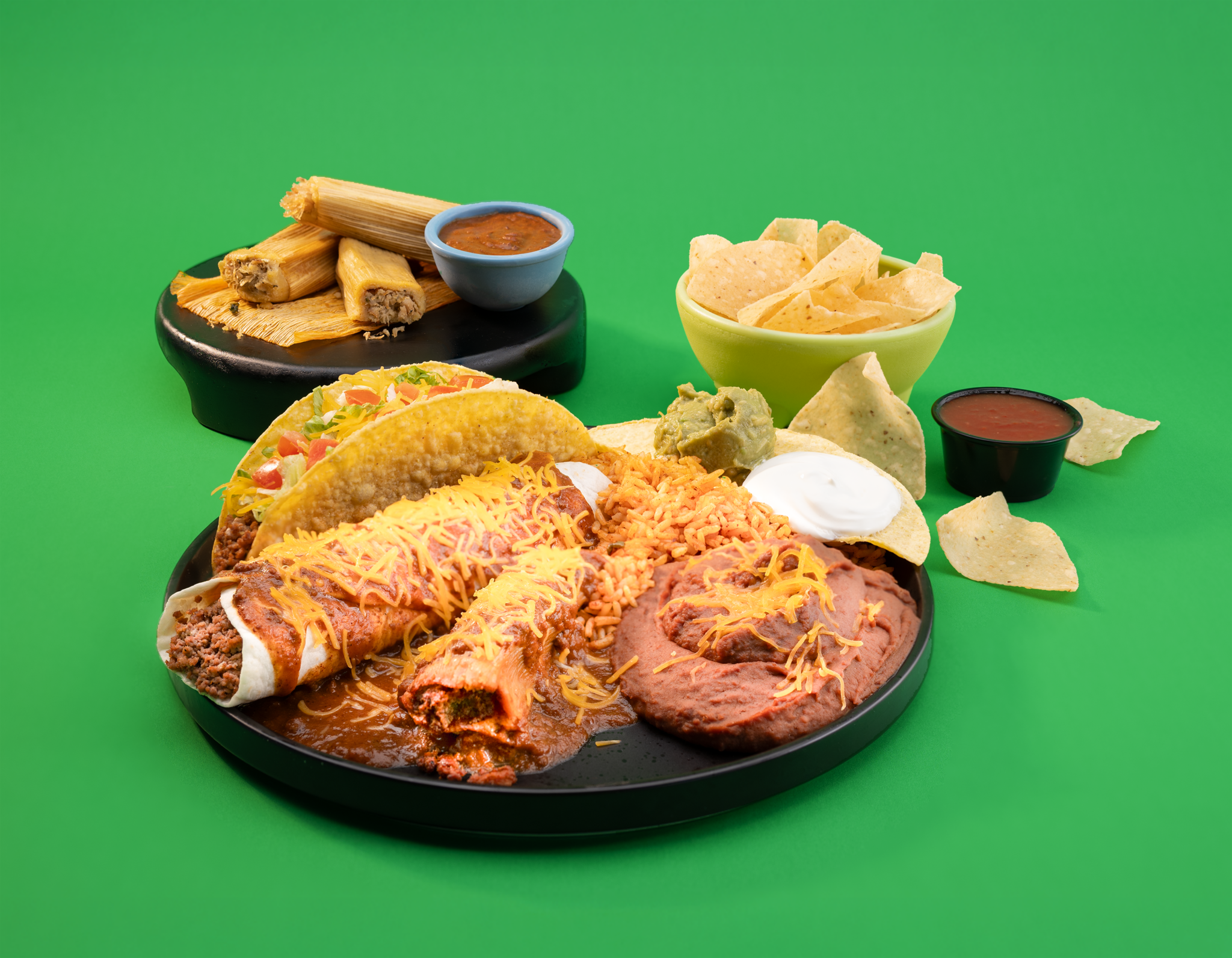 Taco Bueno holiday tamales combo platter with chips, salsa, guacamole, rice, beans, and tamales