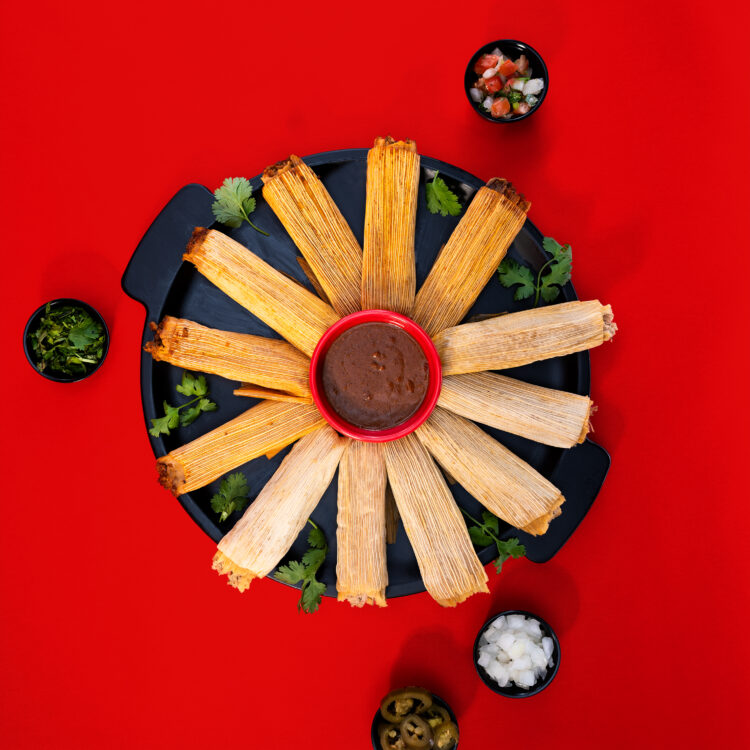 Overhead food photography of Taco Bueno tamales arranged around dipping sauce
